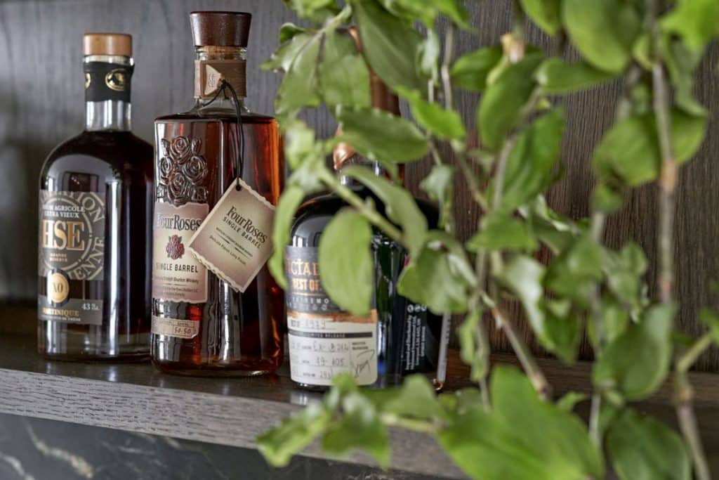 Detail dark wooden bar, supporting bottles of liquor