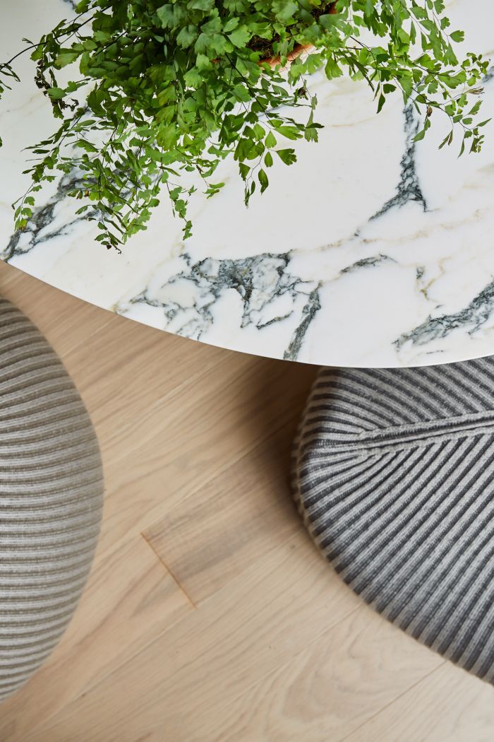 A pair of Casalis outdoor poufs sit below a Tom Faulkner table with marble top.