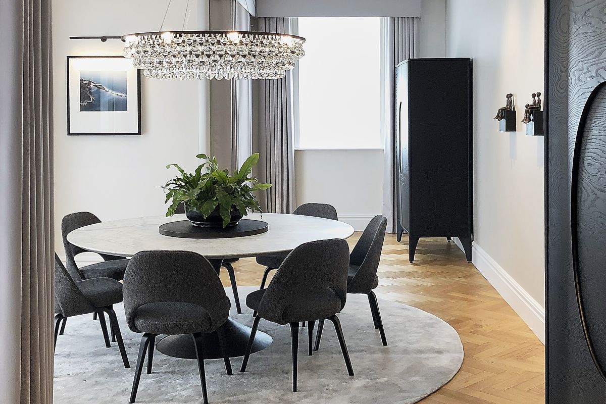 A classic contemporary dining room with round carrara marble Restoration Hardware dining table on round rug.