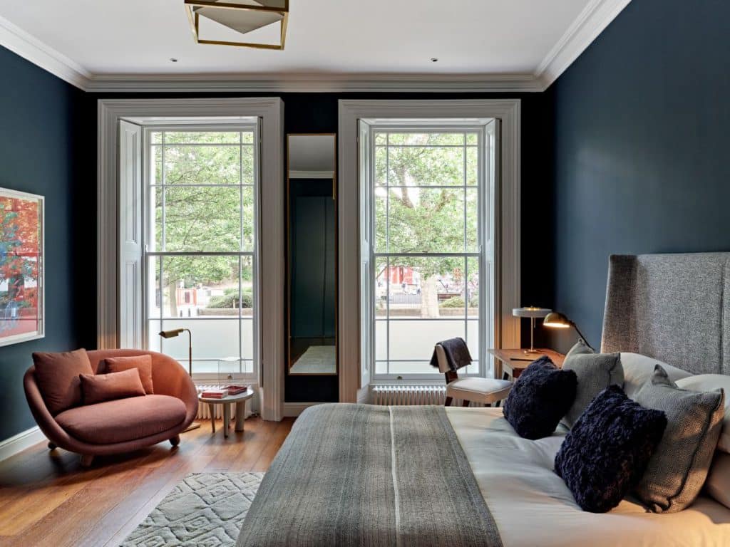 A moooi love sofa in red in front of the window.