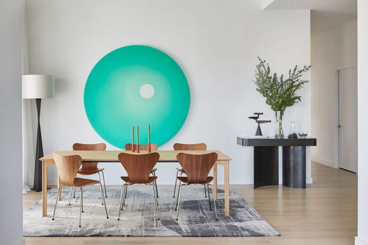 A set of fritz hansen series 6 dining chairs around a wooden dining table in a modern penthouse.