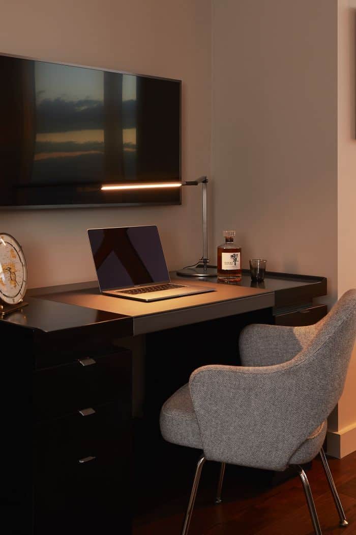 A black lacquered Hugues Chevalier Princeton desk creates a study area in the corner of a principle bedroom.