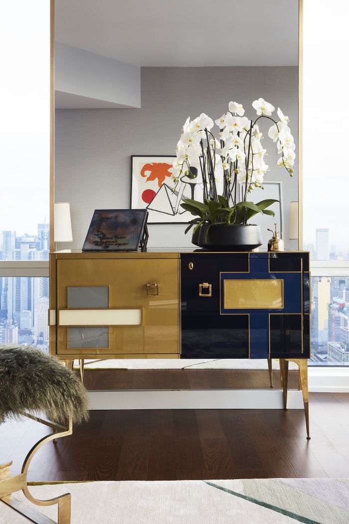 A Mondrian style glass and brass cabinet creates a focal point in the living room. 