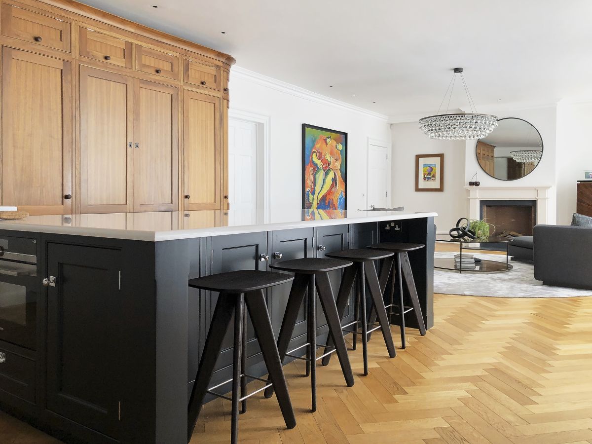 A large blue coloured kitchen island with poliform ICS stools at the bar. 