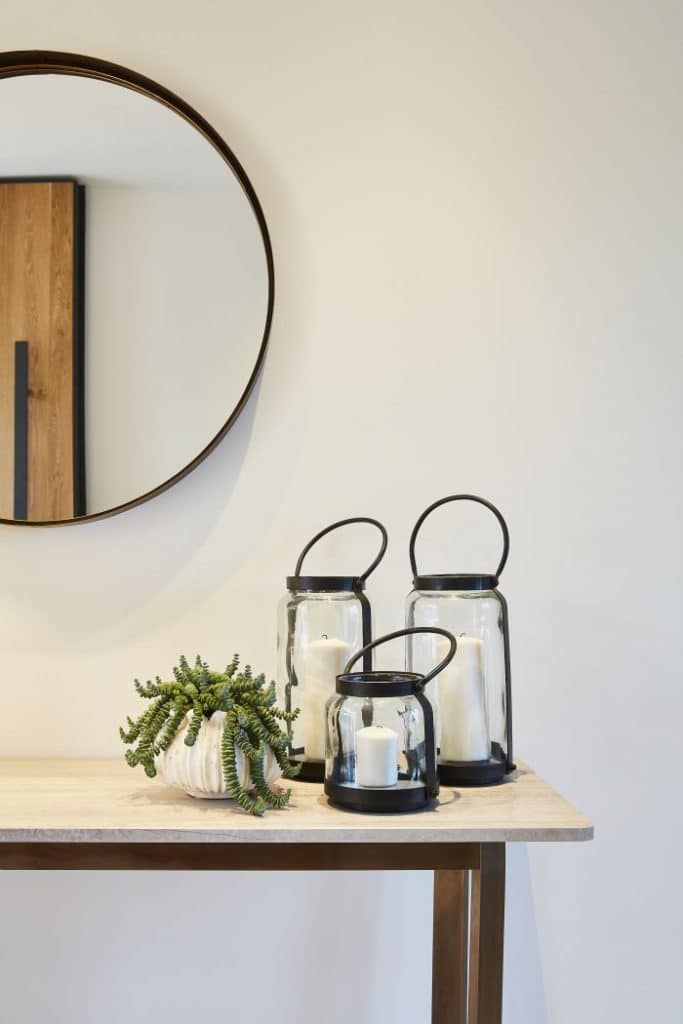 A marble top console table in entrance hallway with circular mirror.