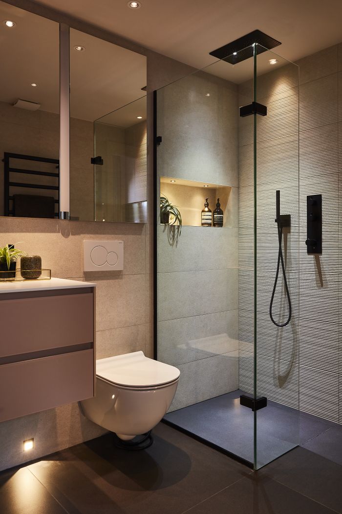 Modern bathroom with black fixtures and pink walls.