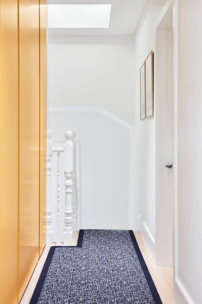 Blue hallway runner with Ochre yellow poliform wardobes for storage.