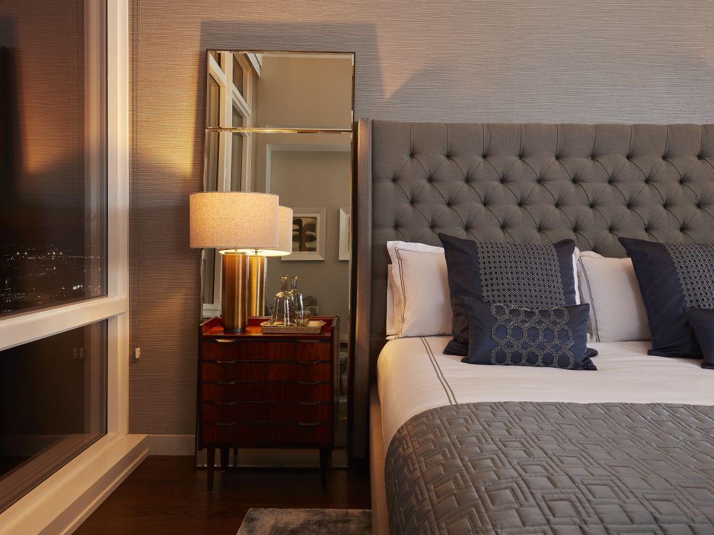 Bedroom details in penthouse showing luxury linens on the bed.