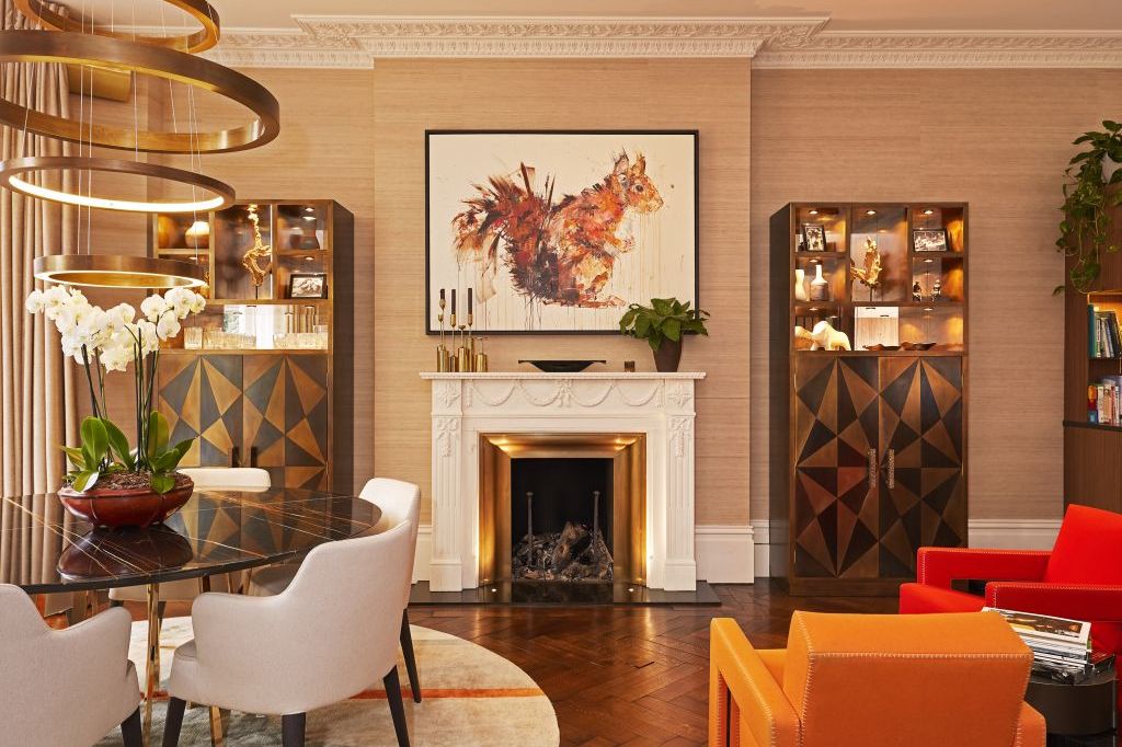 Silk wallpaper on the walls of a living room. On the left side of the room a Sahara noir marble round dining table is situated.