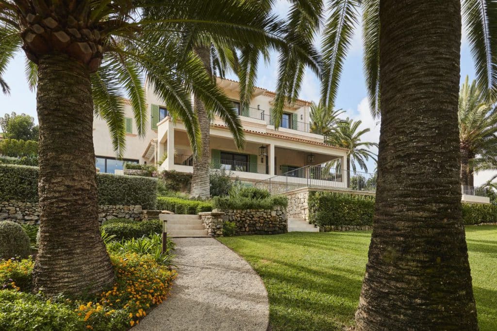 The lush green gardens of a tropical villa garden in Mallorca with pebble path.