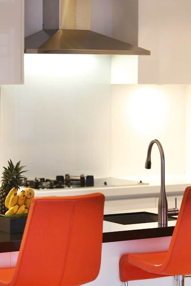 Orange leather Banaldo barstools in white gloss kitchen. 