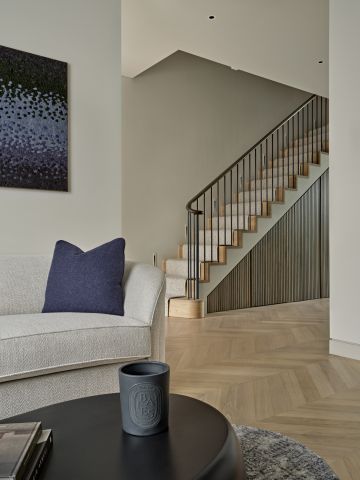 Neutral tone entrance hall to living area. Some blue accents are visible in the living space.