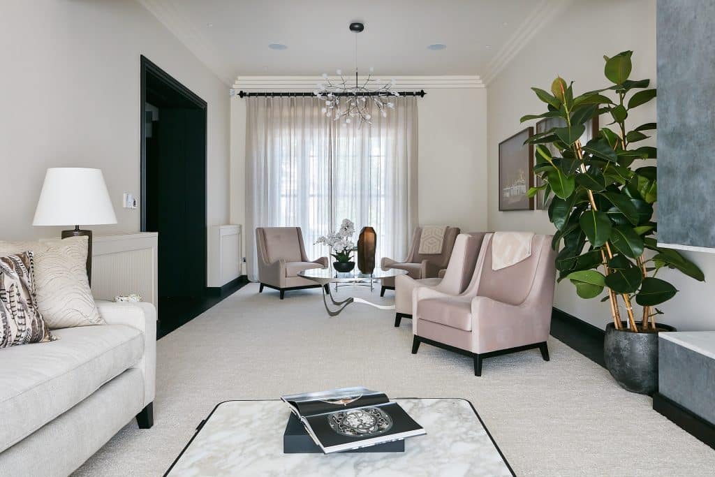 Neutral reception room with blush pink armchairs.