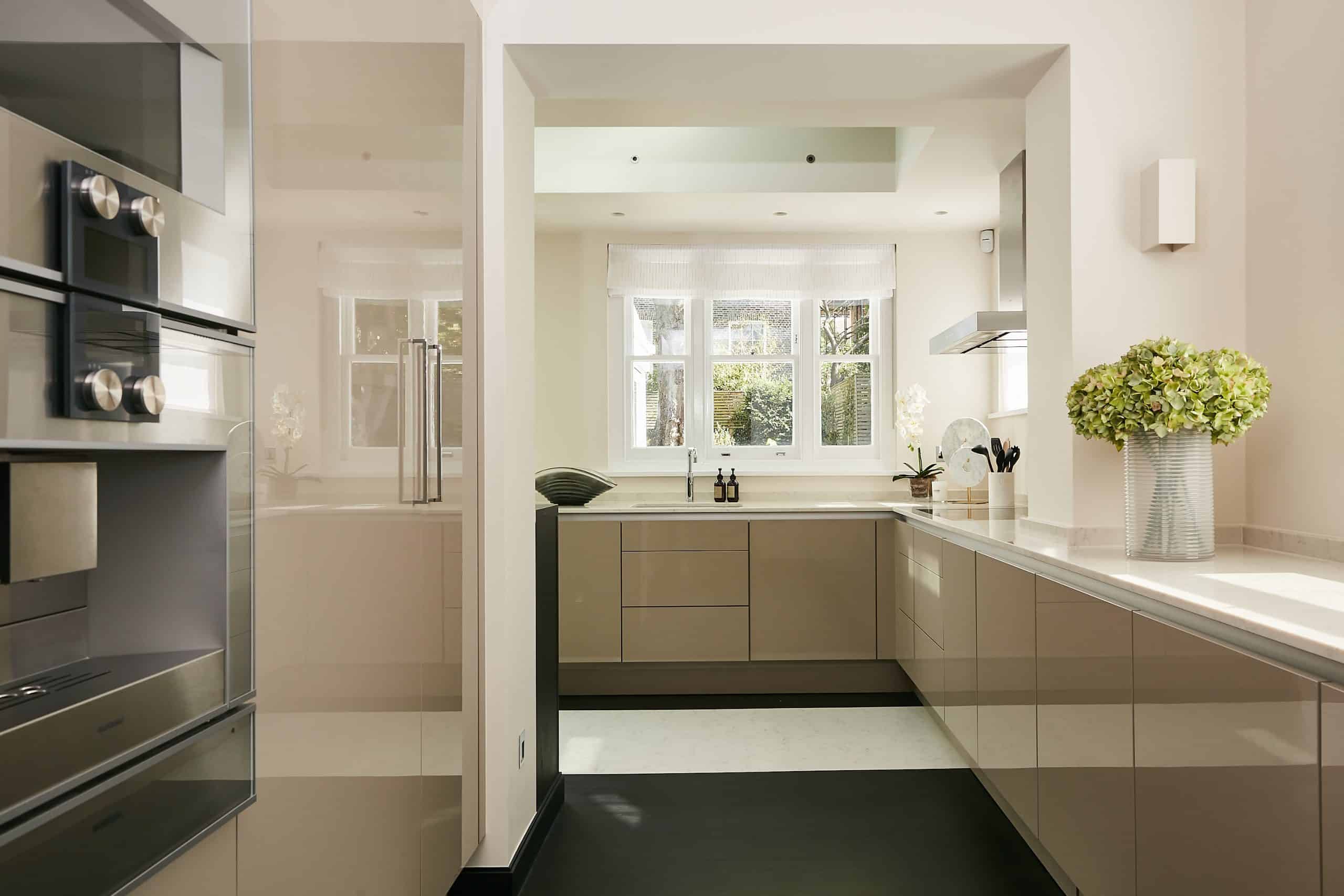 Light neutral modern kitchen with build in oven.