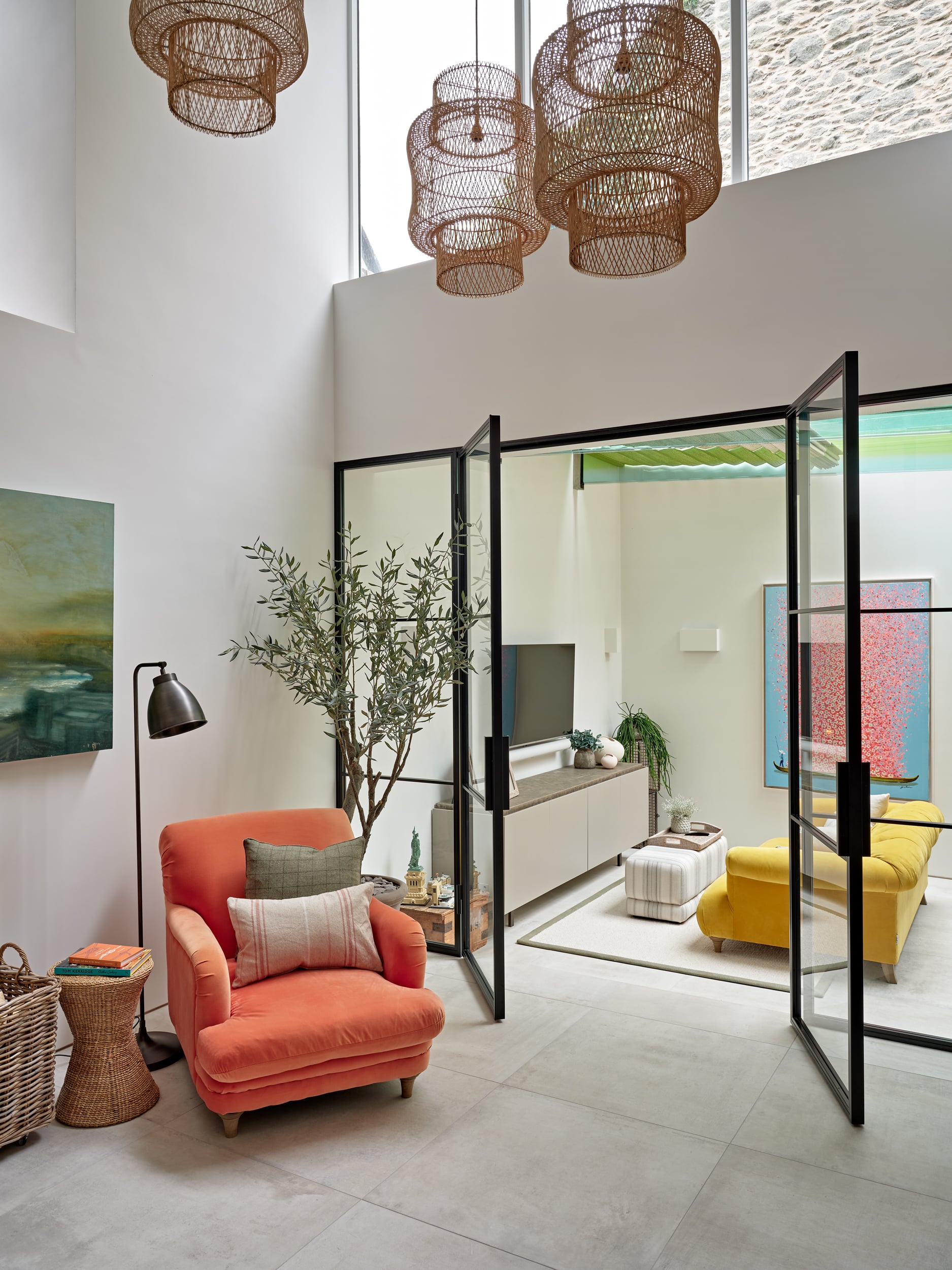 Reading area and media room in Coastal Style house. Both of the spaces are decorated with bright coloured furniture.