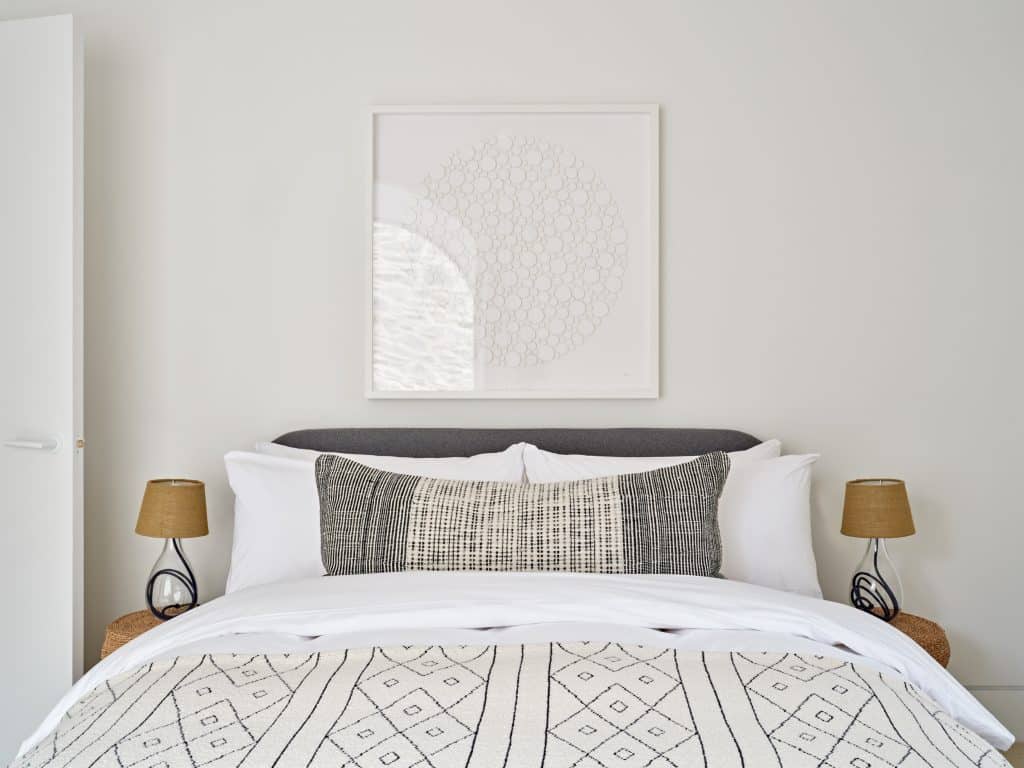 Neutral bedroom with rattan bedside tables.