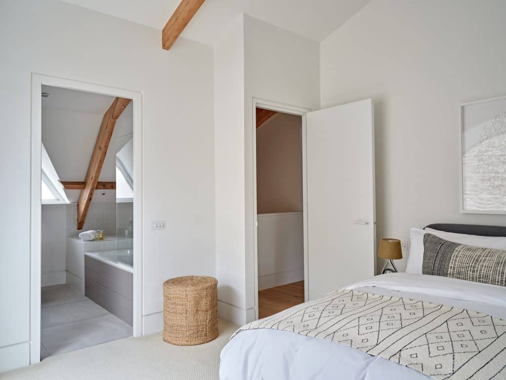 Light and neutral bedroom with en-suite bathroom.