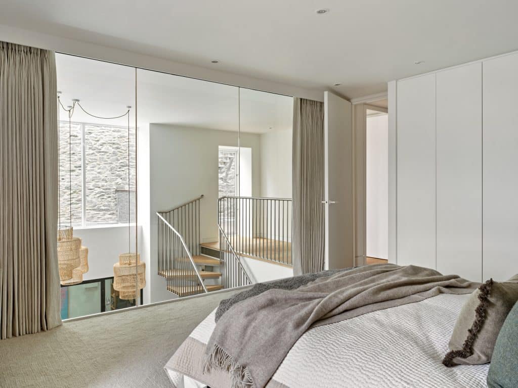 Glass wall in principle bedroom which shows a view to the living space from the bedroom.