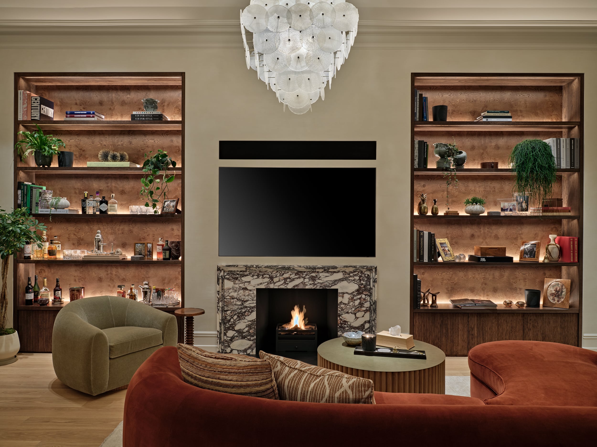 Cozy living space in Central London apartment.On the two sides of the TV and Fireplace there are bespoke shelves displaying sentimental items lovingly collected by the owner.