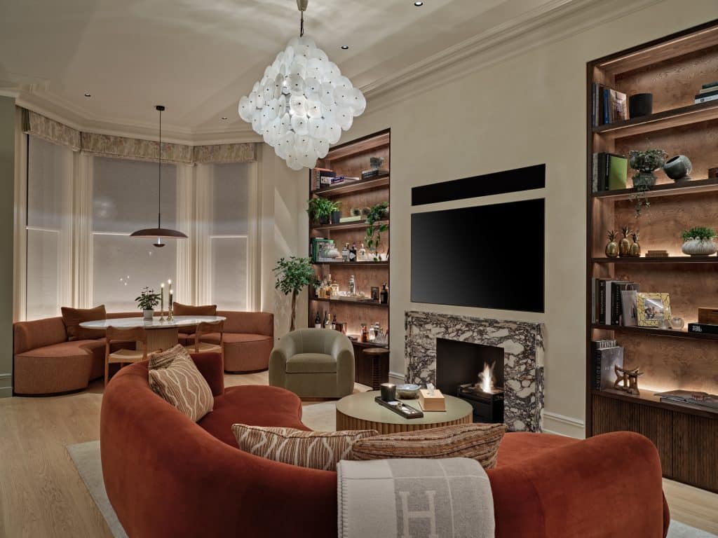 Cozy living space in Central London apartment.On the two sides of the TV and Fireplace there are bespoke shelves displaying sentimental items lovingly collected by the owner.