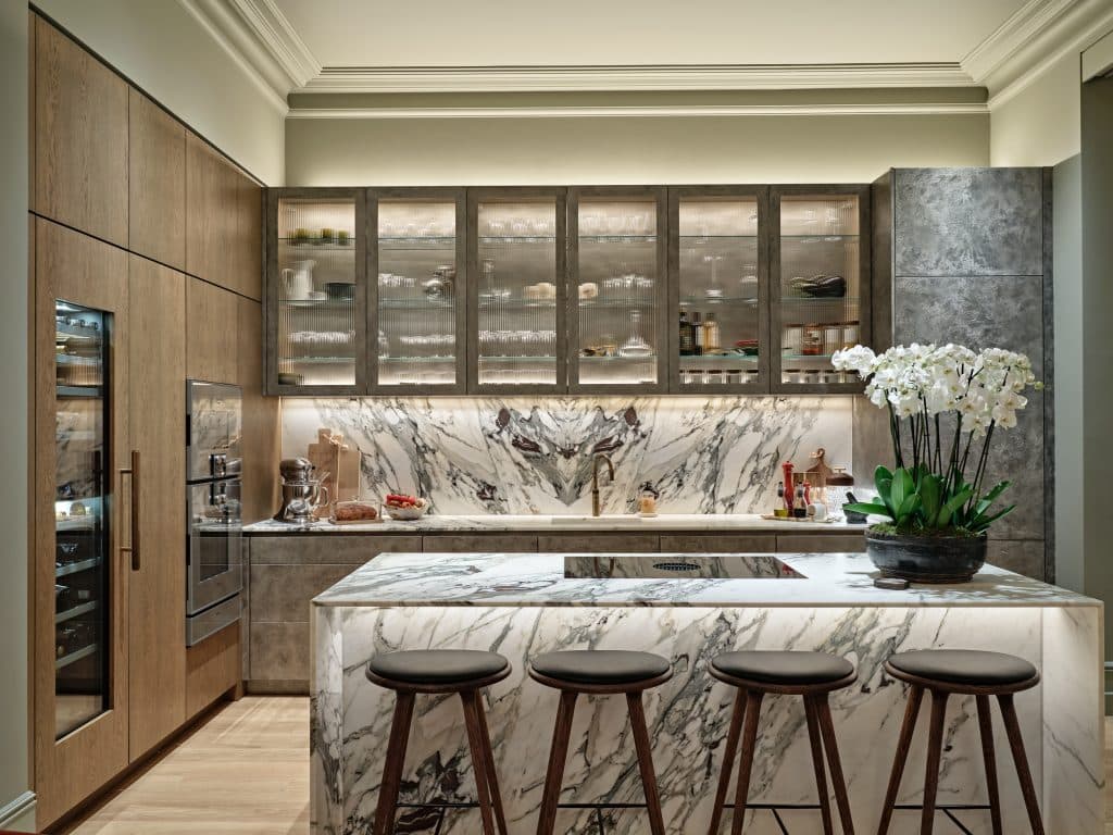 Beautiful marble kitchen with bespoke cabinetry. In the cabinetry there is a wine fridge, steam oven and regular oven.