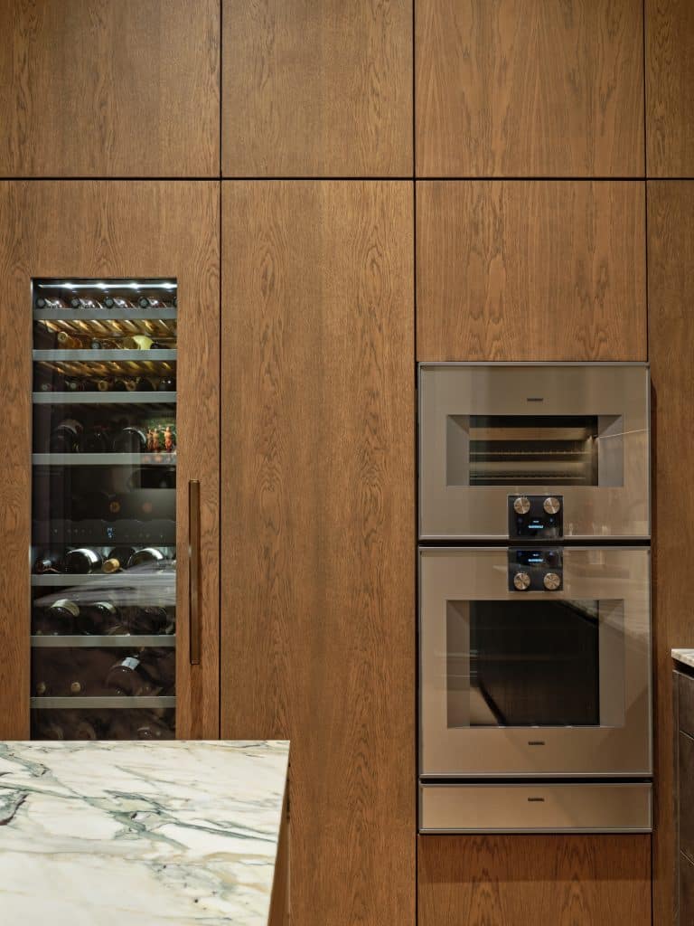 Built in wine fridge, steam oven and regular oven in bespoke cabinetry in kitchen.